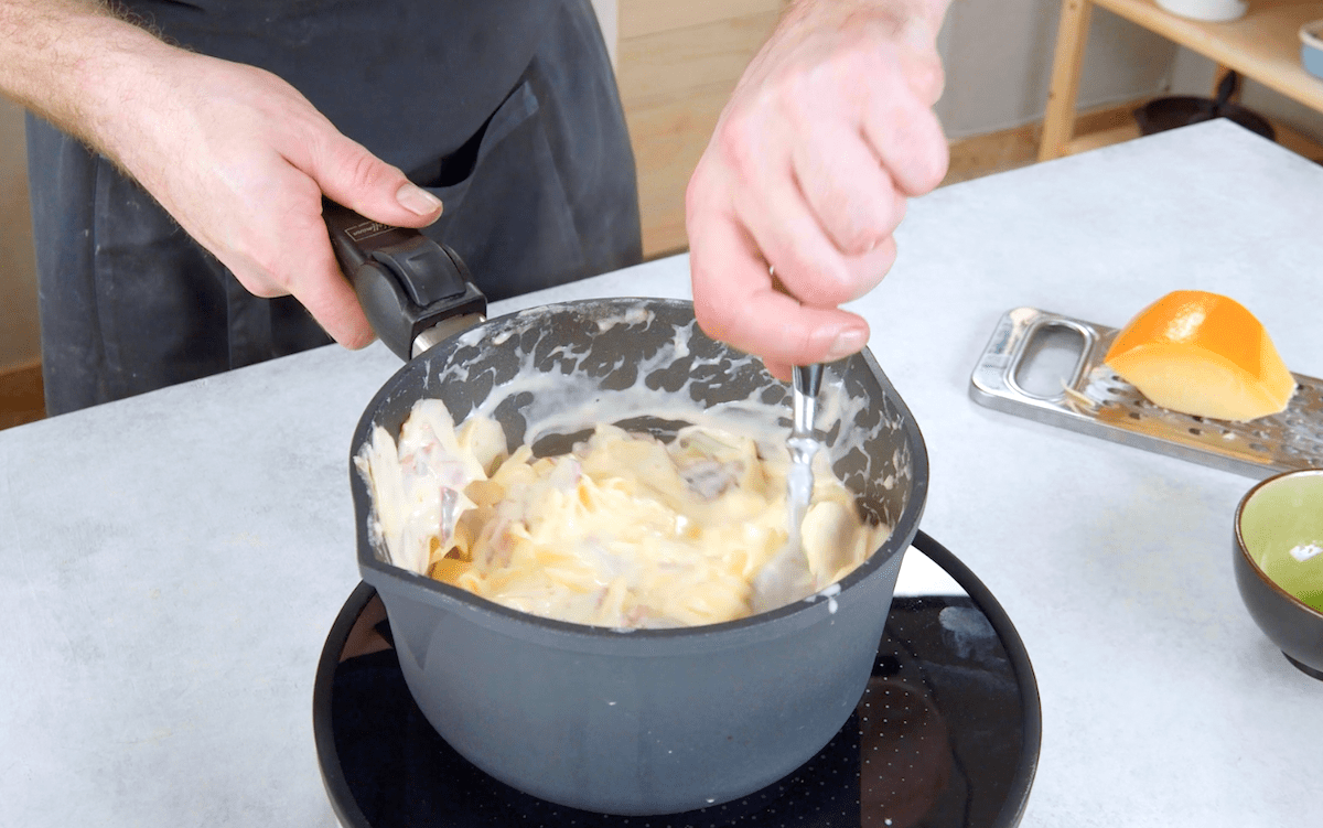 Kartoffelgratin wird in einer hohen Pfanne zubereitet.