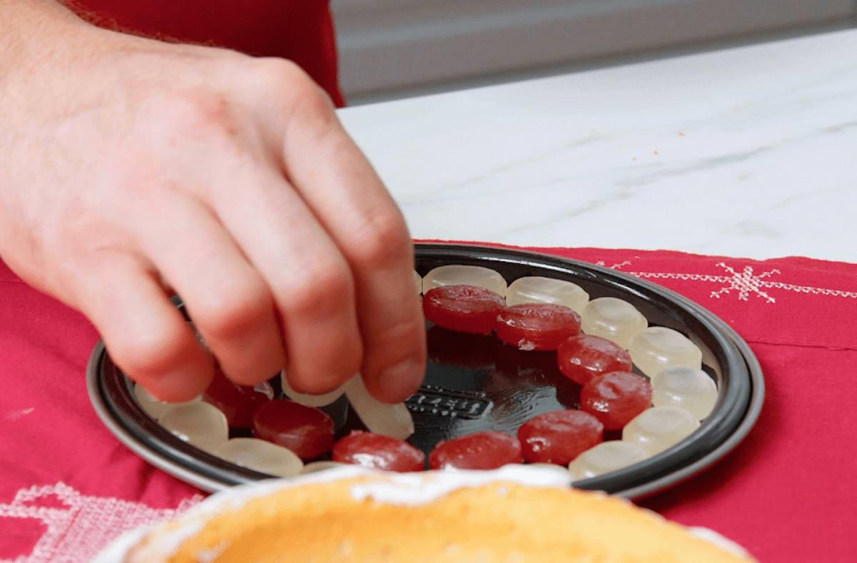 Bonbons werden im Kreis auf eine Kuchenplatte gelegt