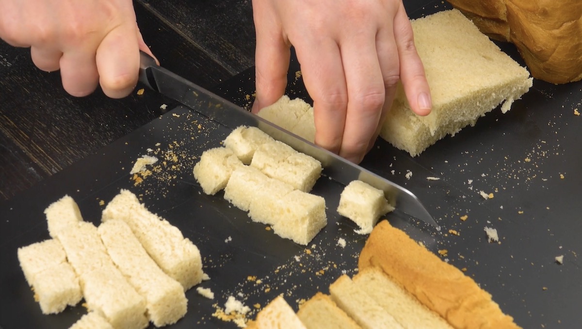 Das Innere mehrerer Toastscheiben wird in kleine StÃ¼cke geschnitten
