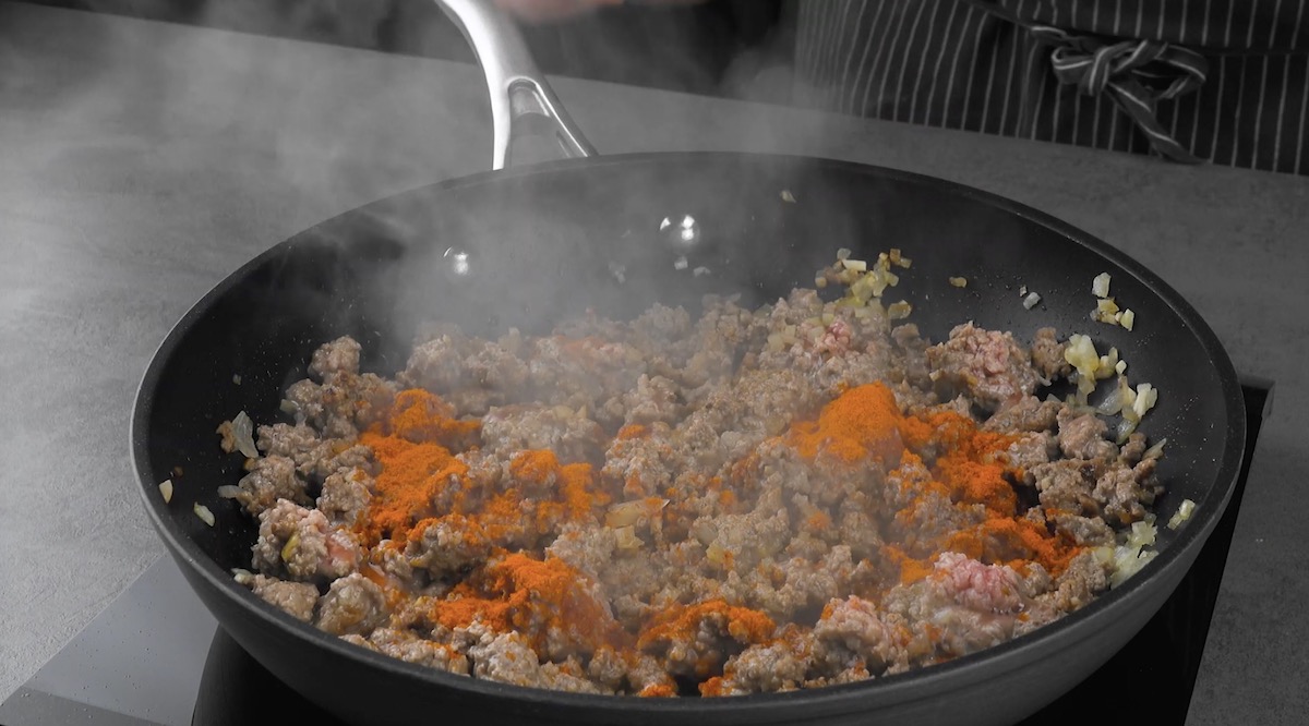 Hackfleisch wird mit Zwiebeln, Knoblauch und Paprikapulver angebraten