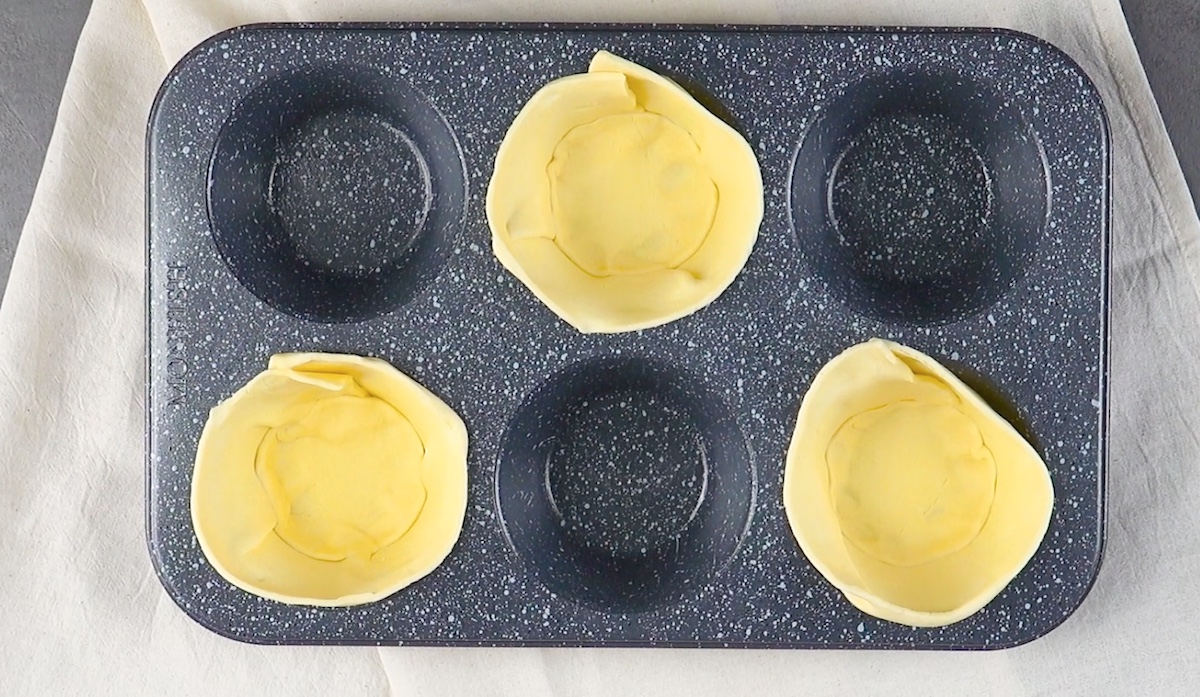 Blätterteig wird in Muffinförmchen gelegt