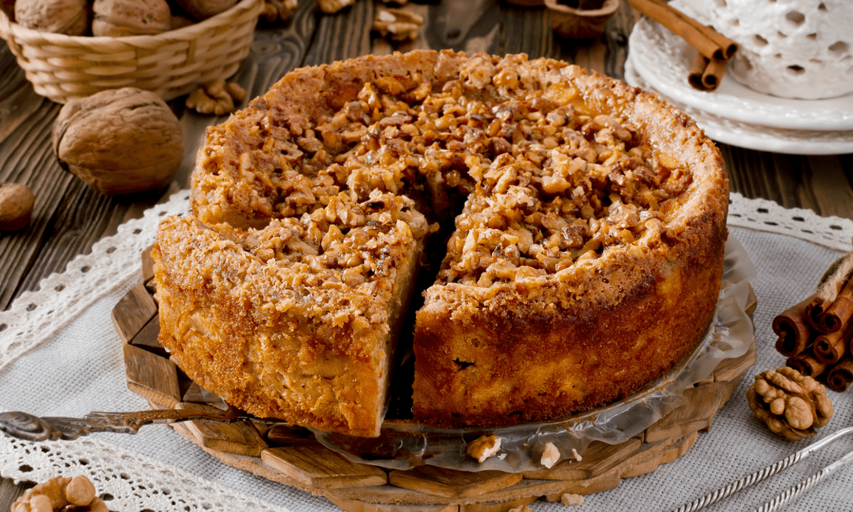 Apfel-Walnuss-Kuchen, serviert auf einem runden Blech.