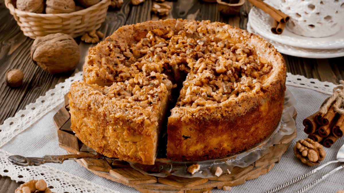 Apfel-Walnuss-Kuchen, serviert auf einem runden Blech.