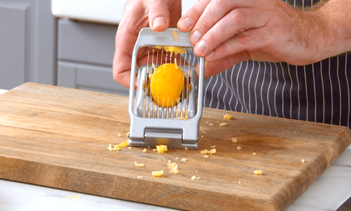 Eine gekochte Kartoffel wird mithilfe eines Eierschneiders klein geschnitten