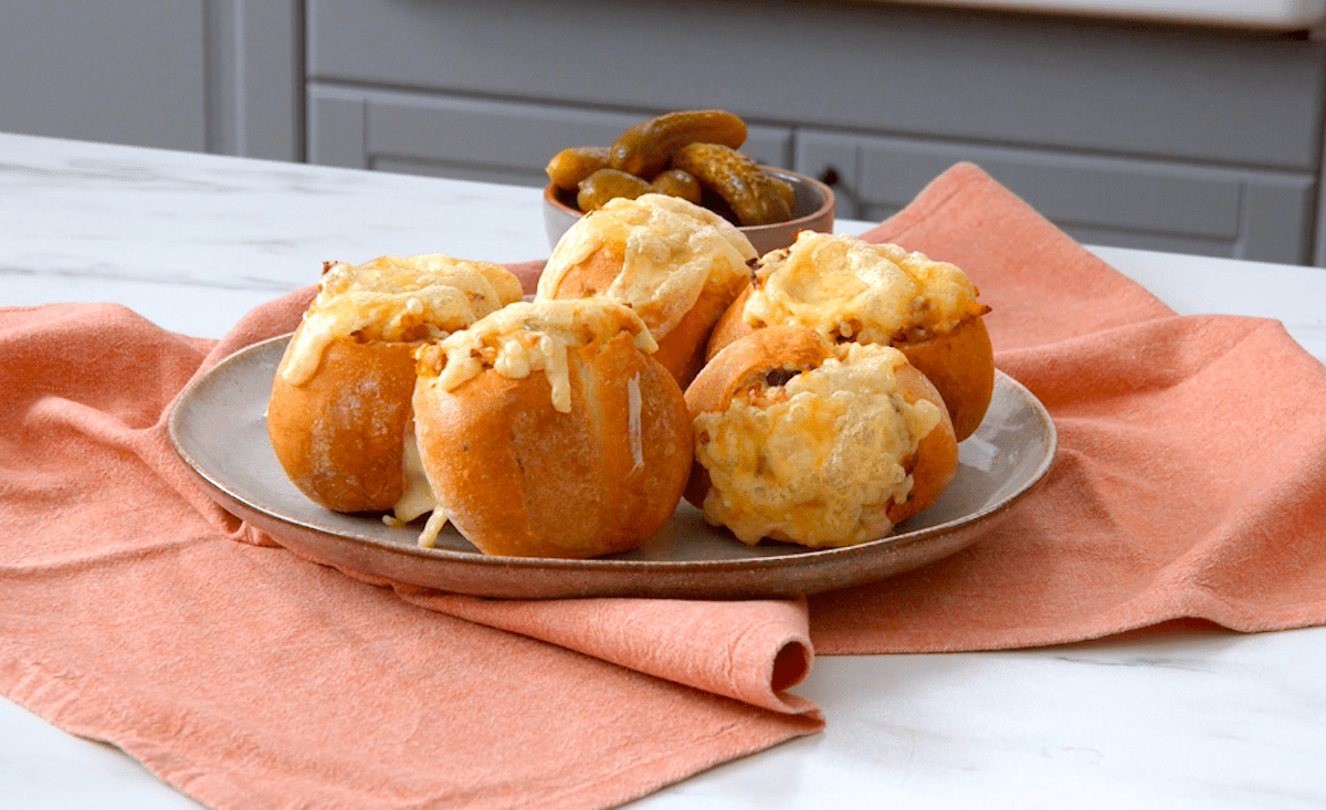 Rustikales Bauernfrühstück in kleinen Brötchen, mit Käse überbacken