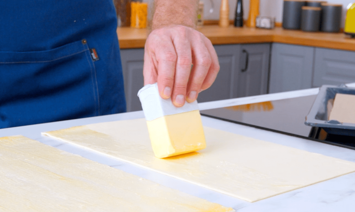 Butter wird auf ausgerollten BlÃ¤tterteig verstrichen