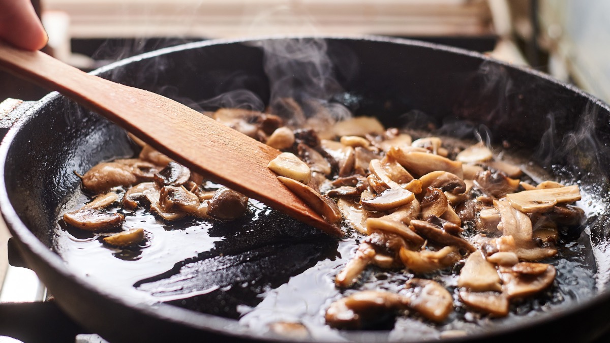 Braten ohne Fett: Ein e Pfanne, in der Champignons angebraten werden.