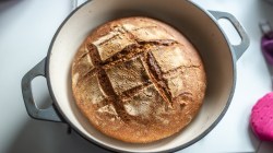 Ein selbst gebackenes Brot in einem Topf in der Draufsicht von oben.
