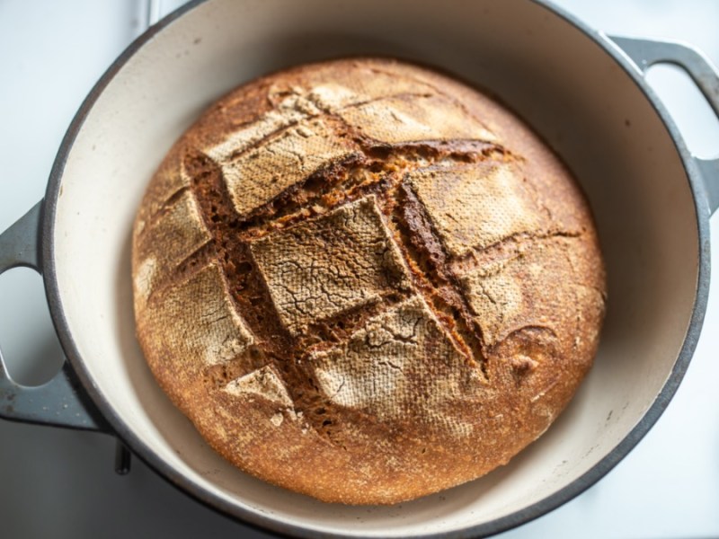 Ein selbst gebackenes Brot in einem Topf in der Draufsicht von oben.