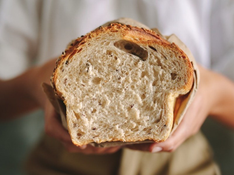 Brot selber backen: ein angeschnittenes Brot wird in Händen gehalten