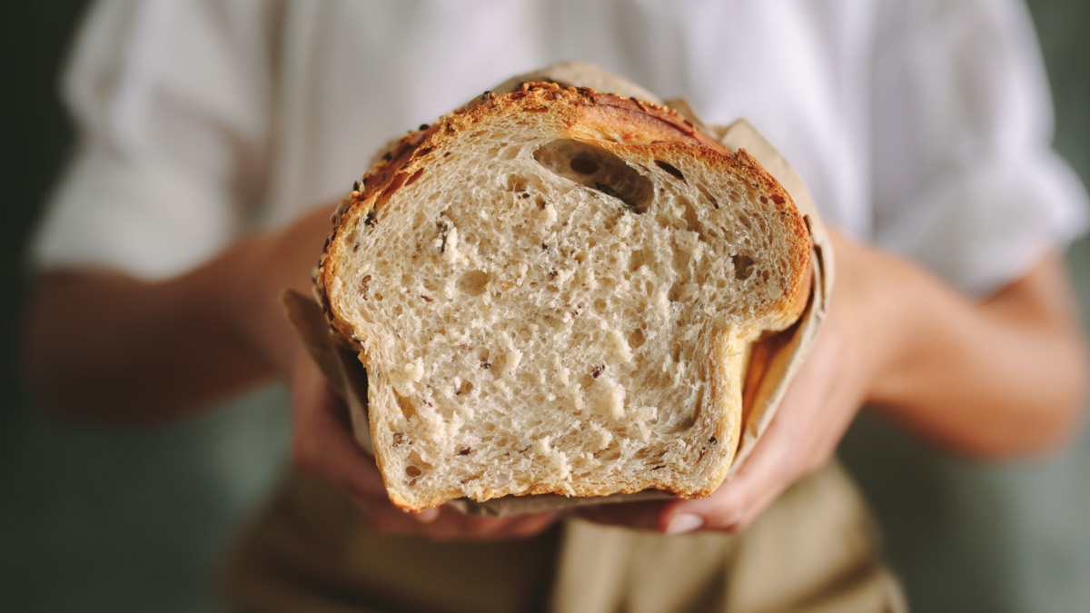 Brot selber backen: ein angeschnittenes Brot wird in Händen gehalten