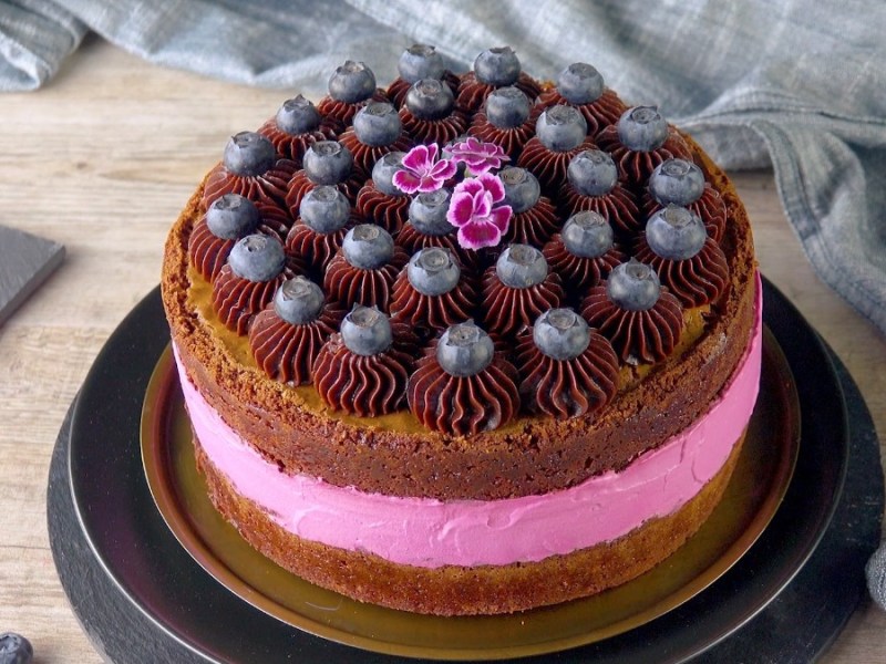 Saftige Brownie-Beeren-Torte mit Schokoladentupfen und frischen Blaubeeren.