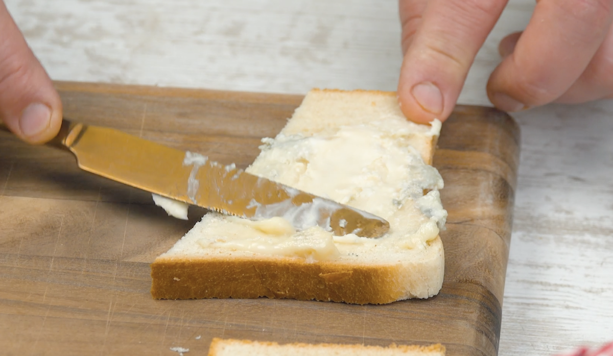 Die grÃ¶ÃŸere HÃ¤lfte einer Toastscheibe wird mit Gorgonzola bestrichen
