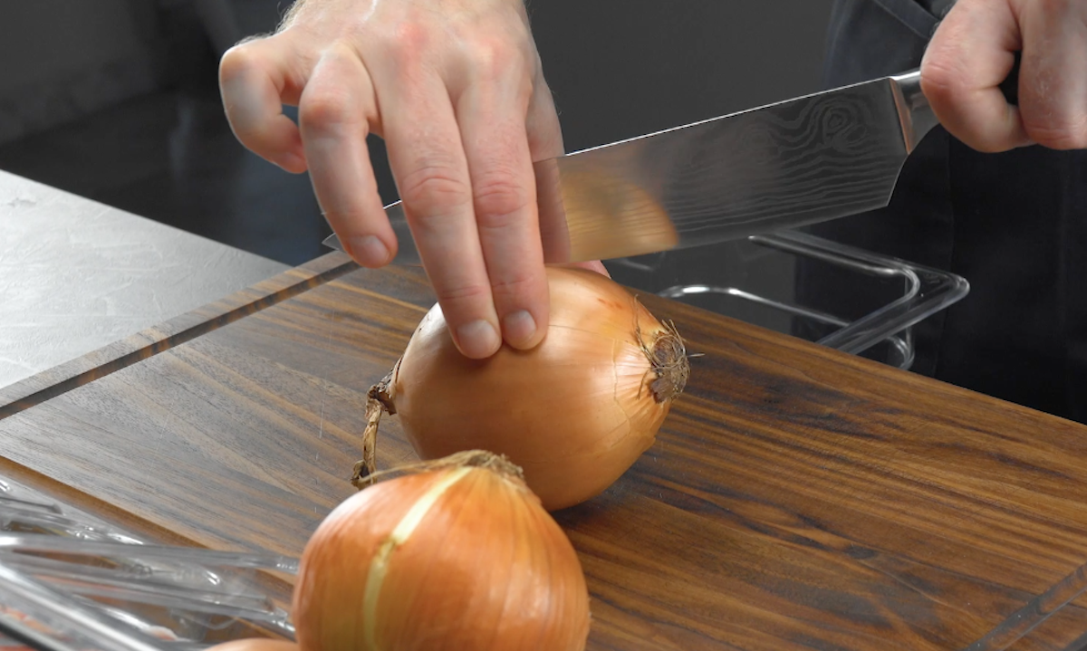 Zwiebel wird mit Messer halbiert