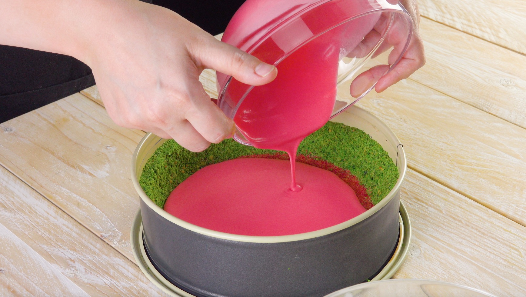 Rosafarbene Creme wird in Mitte der Kuchenform gefÃ¼llt