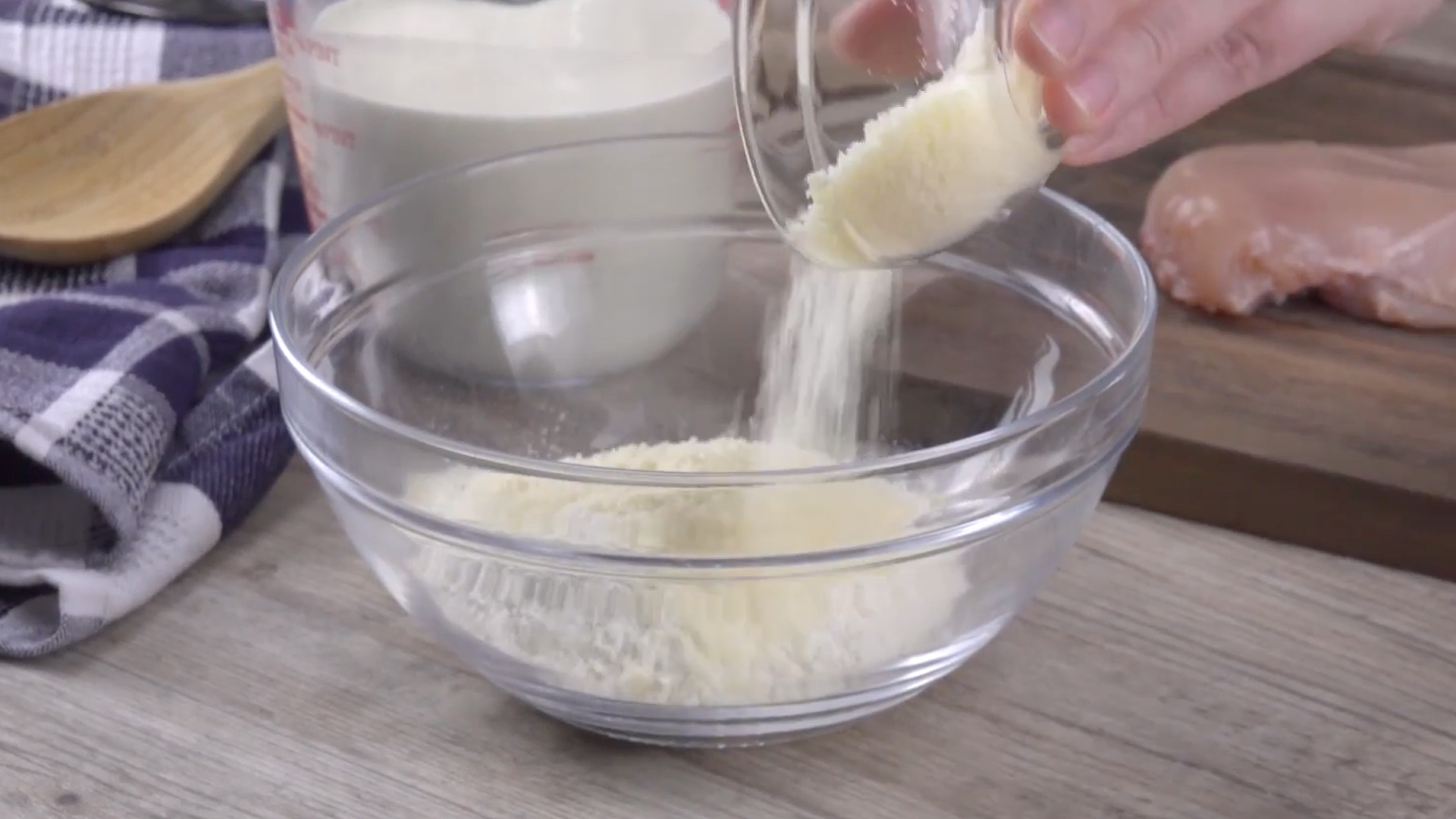Parmesan wird zusammen mit Mehl in eine gläserne Schüssel gegeben.