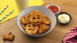 Emoji-Pommes in einer Schüssel, daneben Schüsseln mit Ketchup und Mayo.