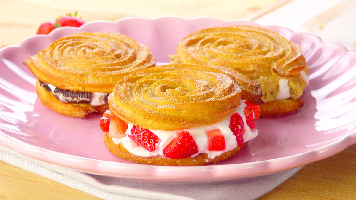 3 Churro-Sandwiches mit verschiedenen Füllungen auf Teller