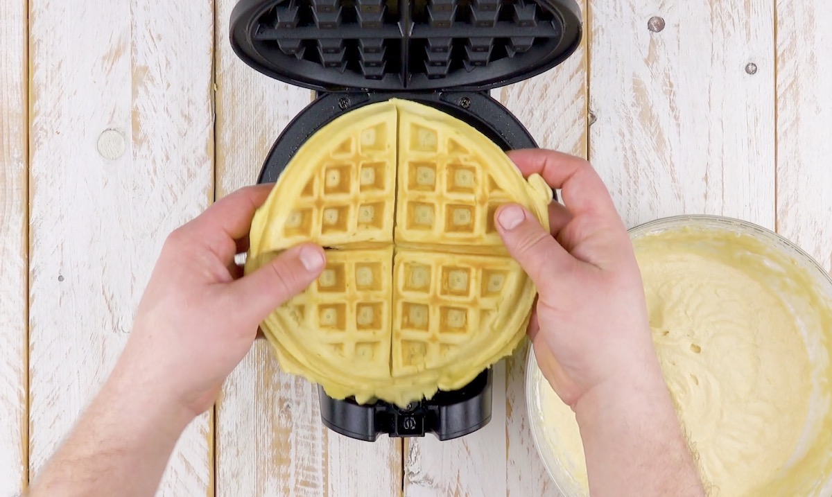 Eine Waffel wird aus einem Waffeleisen geholt