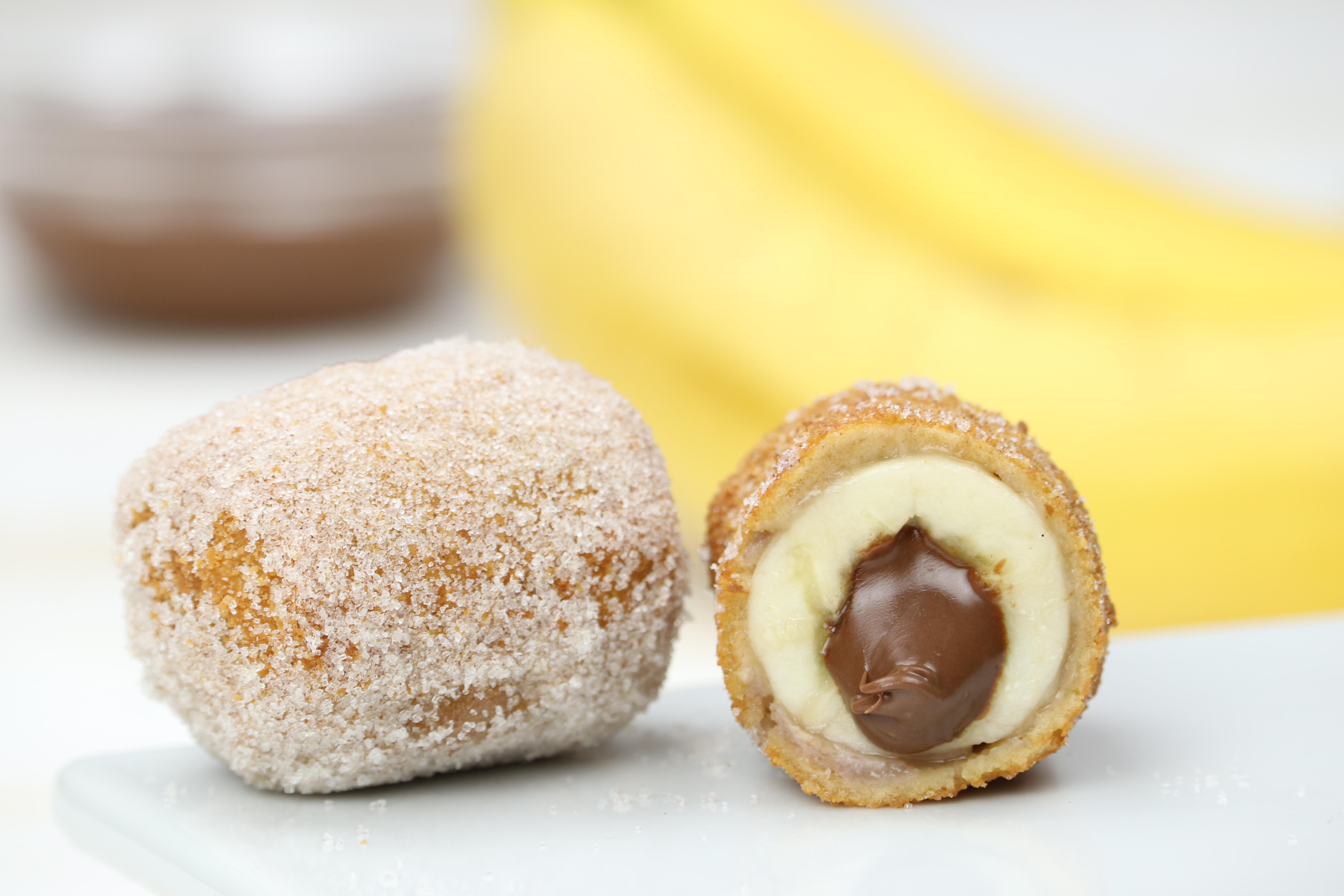 Zwei Bananen-Nutella-Kroketten, eine davon aufgeschnitten.