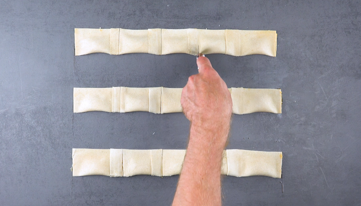 Ravioli aus Toastbrot werden mit Pizzaschneider zurechtgeschnitten