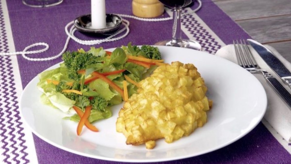 Kartoffel-Cordon-bleu mit Salatbeilage auf weißem Teller