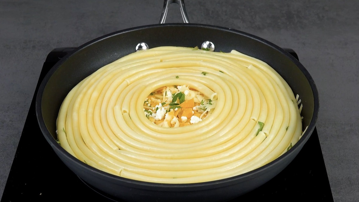 Eine weitere Schicht Nudel kommt nach einer Schicht Käse in die Pfanne