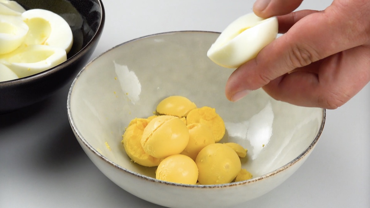 Eigelbe und EiweiÃŸe von gekochten Eiern werden in getrennte SchÃ¼sseln gegeben