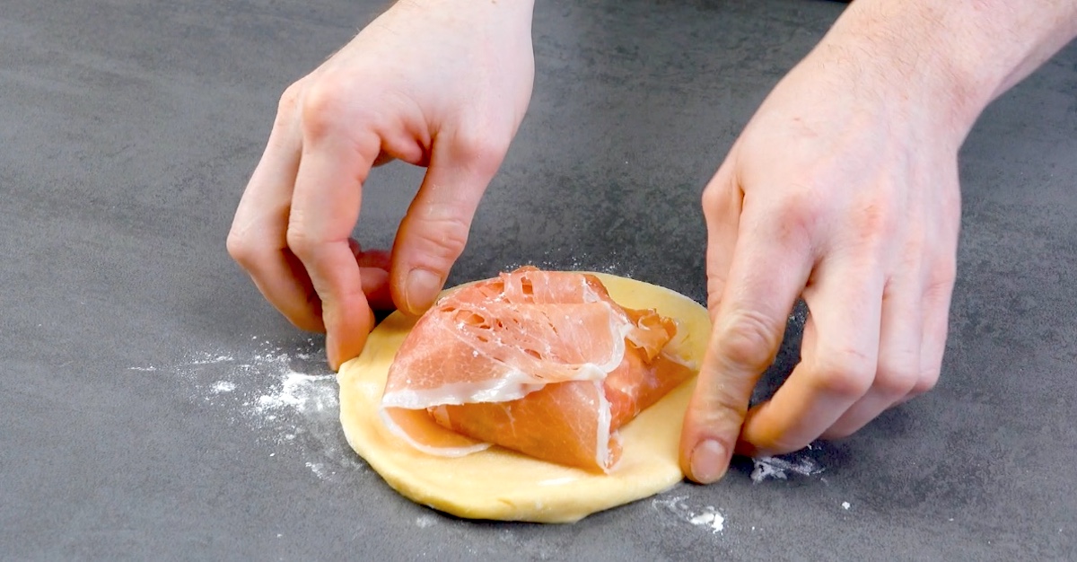 Schinkenscheiben werden über pochiertes Ei geklappt