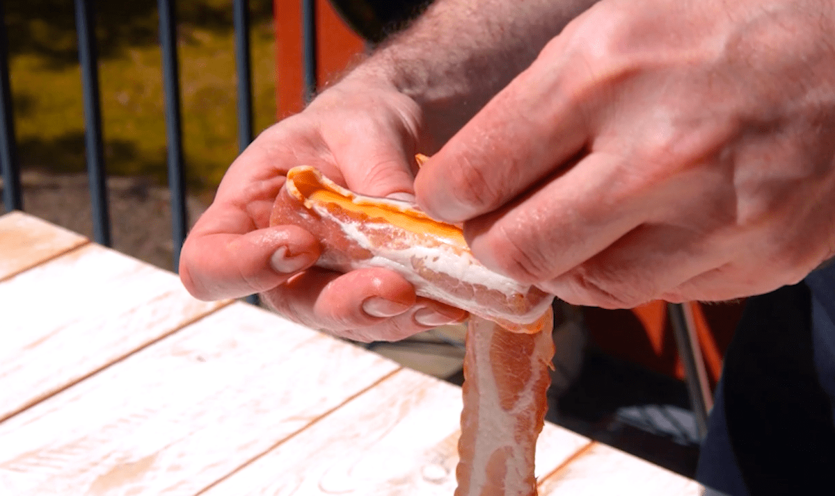 Mit Hackfleisch gefÃ¼llte Cannelloni werden mit Bacon umwickelt