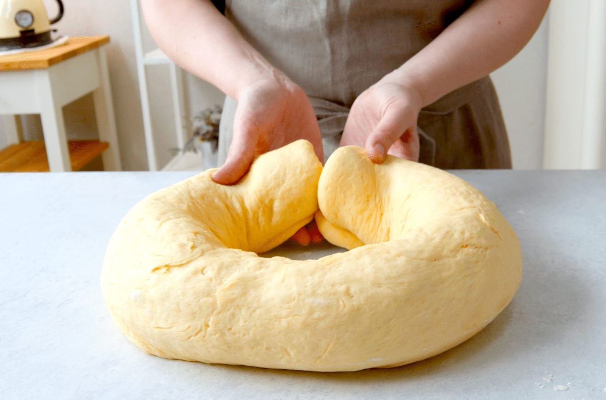 Ein gefÃ¼llter Teig wird zu einem groÃŸen Donut geformt