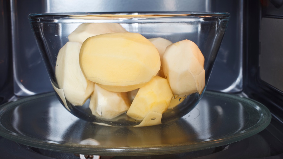 Geschälte Kartoffel in Glasschale in einer Mikrowelle.