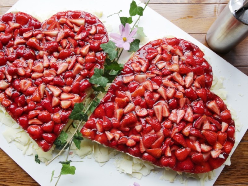 Zwei Muttertagskuchen mit Erdbeeren in Herzform.