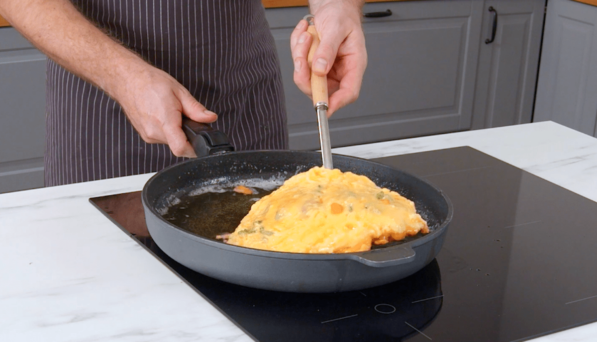 Hühnchenbrust in Parmesan-Hülle wird in einer Pfanne angebraten