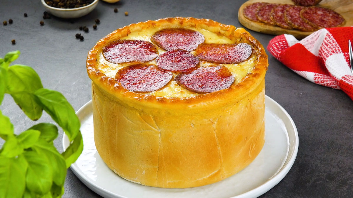 Ein Pizzakuchen mit Salami auf einem Teller.