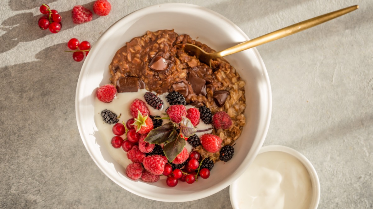 Eine SchÃ¼ssel Schokoladen-Porridge mit FrischkÃ¤se und roten FrÃ¼chten