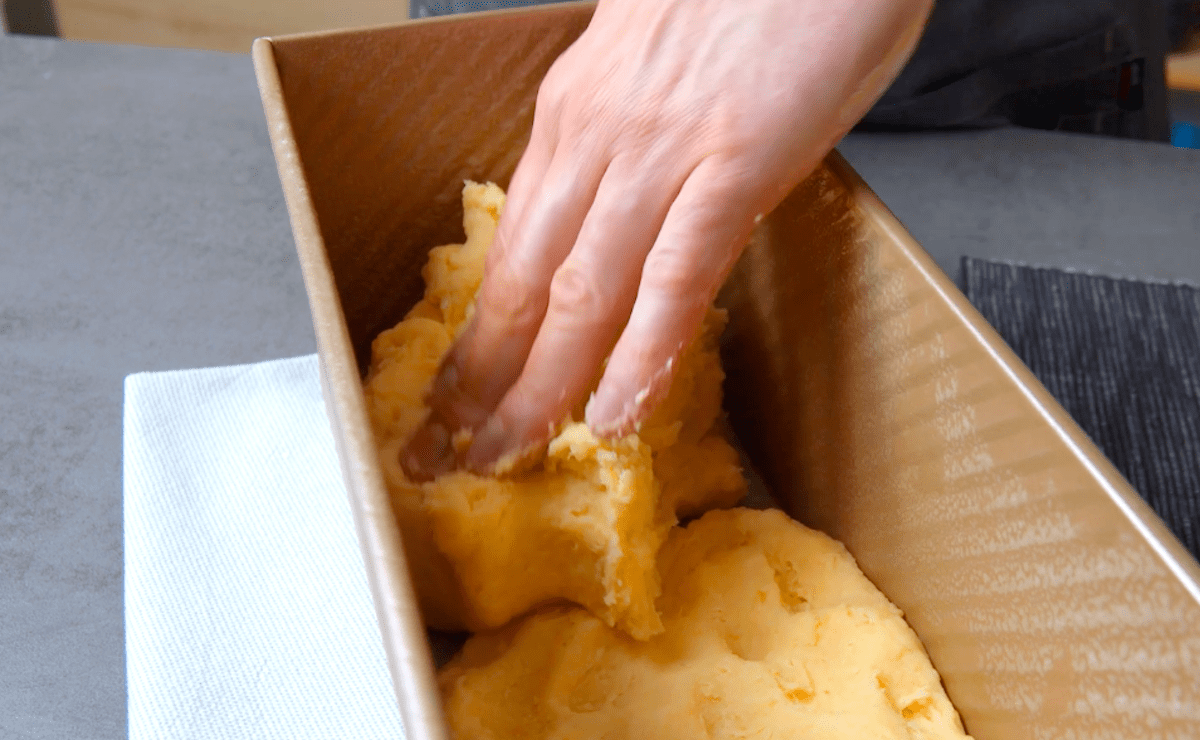 Eine Kartoffelmasse wird in eine Kastenfom gegeben