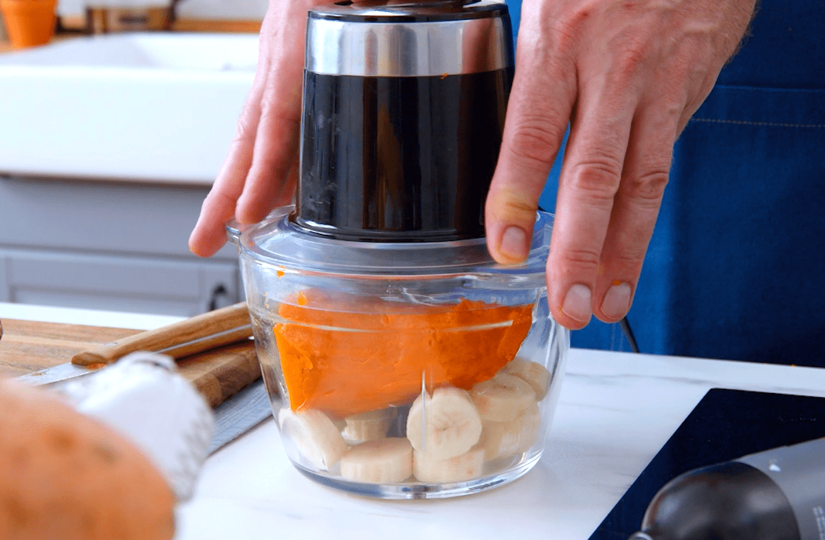 Eine gebackene Süßkartoffel und gefrorene Bananen Scheiben werden in einen Mixer gegeben