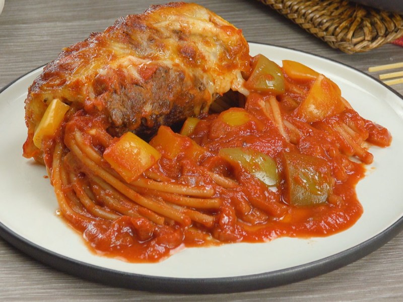 Eine Portion Spaghetti in der Hackfleisch-Rolle auf einem Teller.
