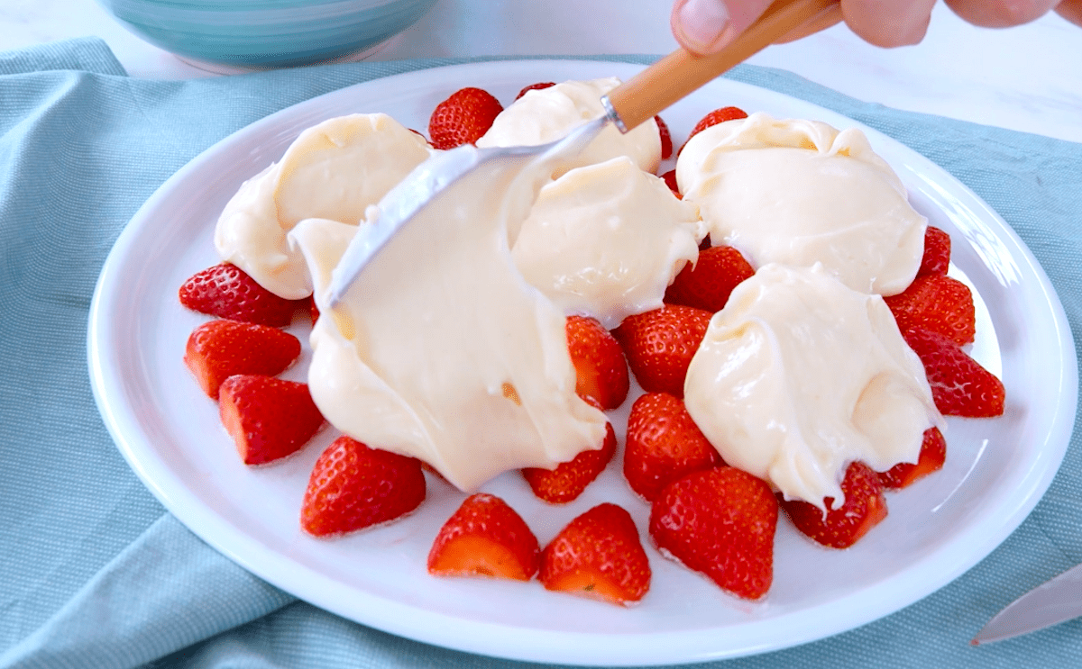 Vanillepudding wird auf Erdbeeren verteilt