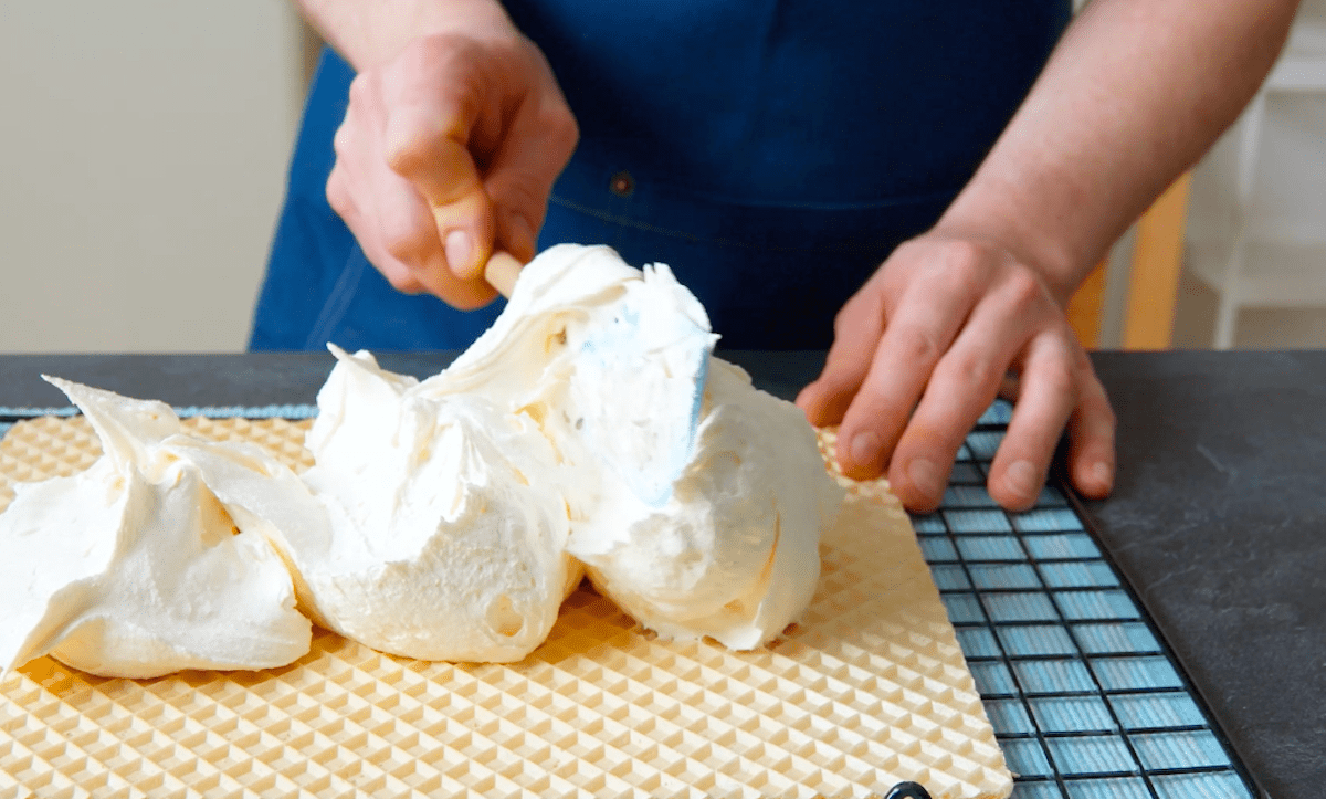 Milchcreme wird auf einer Waffelplatte verstrichen