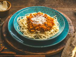 Ein Teller Linsenbolognese, serviert mit Spaghetti und Parmesan.