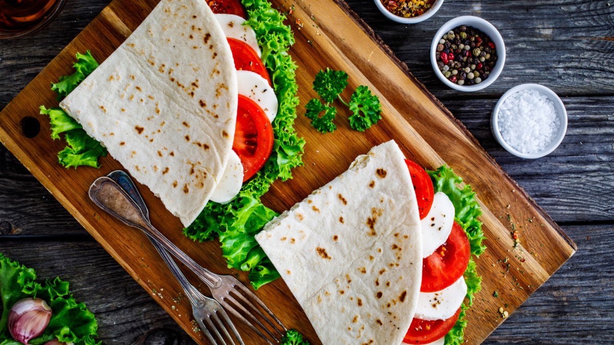 2 Tomaten-Mozzarella-Wraps auf Holzbrett