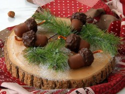 Schokoladen-Eicheln auf einer Baumscheibe mit Tannengrün