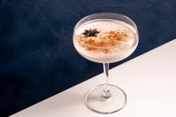Tiramisu Espresso Martini im Martiniglas, dekoriert mit Kakaopulver und einem Anisstern.