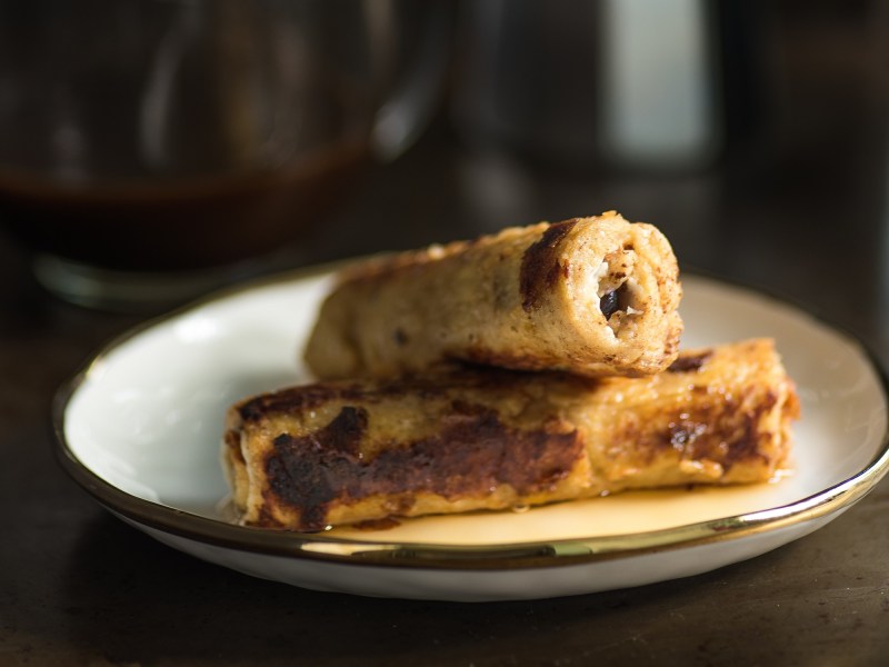 Zwei French Toast Röllchen auf einem Teller.