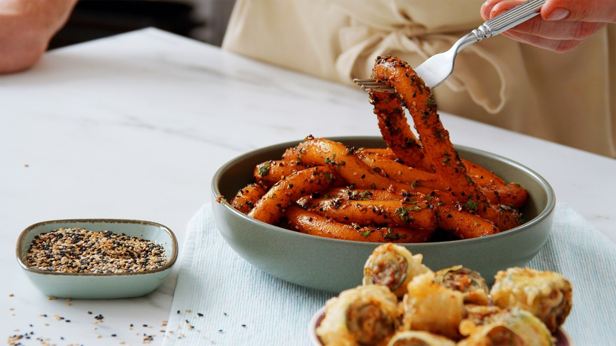 Ein Teller Kartoffelnudeln, daneben eine Schale mit frittierten Zucchini-Röllchen und eine Schale Sesam.