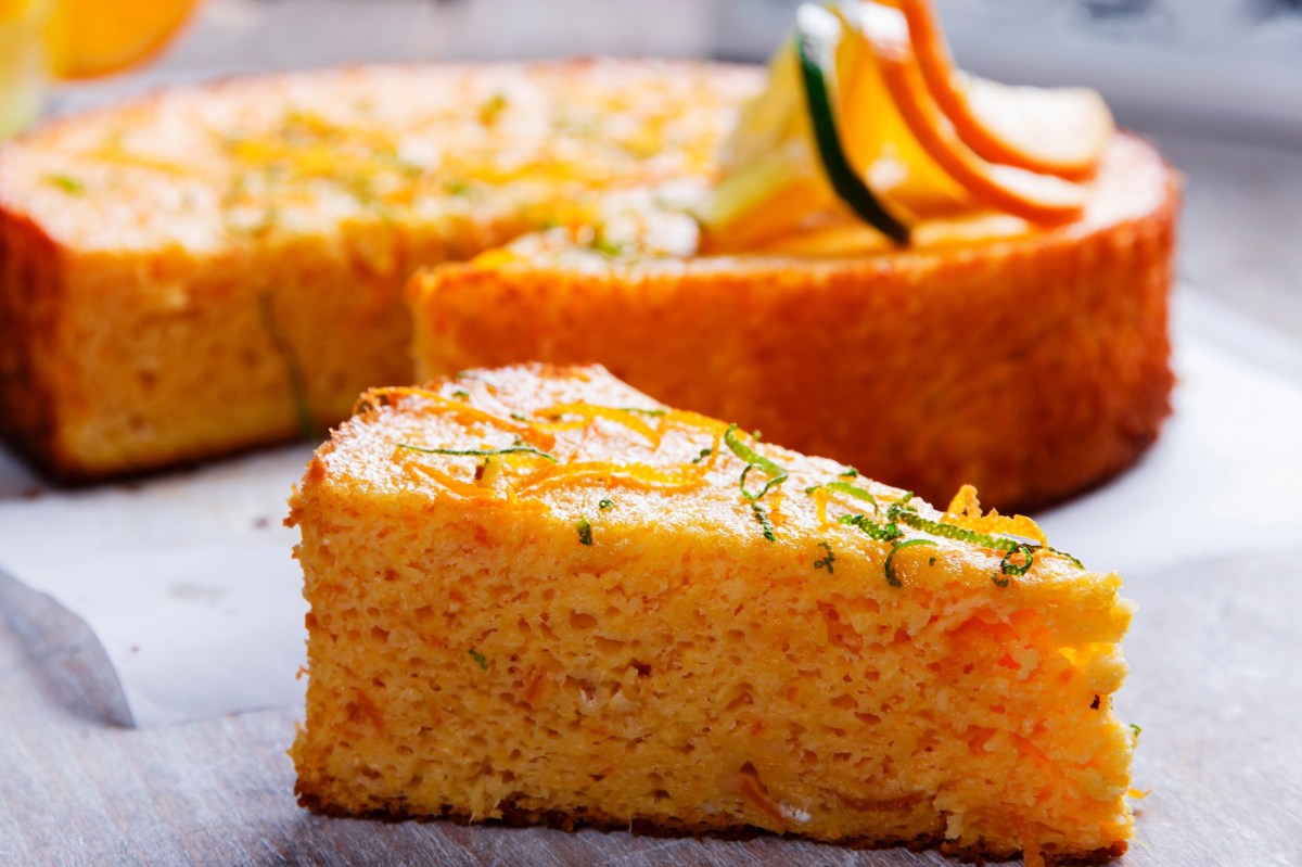 Ein Stück saftiger Orangen-Mandel-Kuchen mit Zeste bestreut.