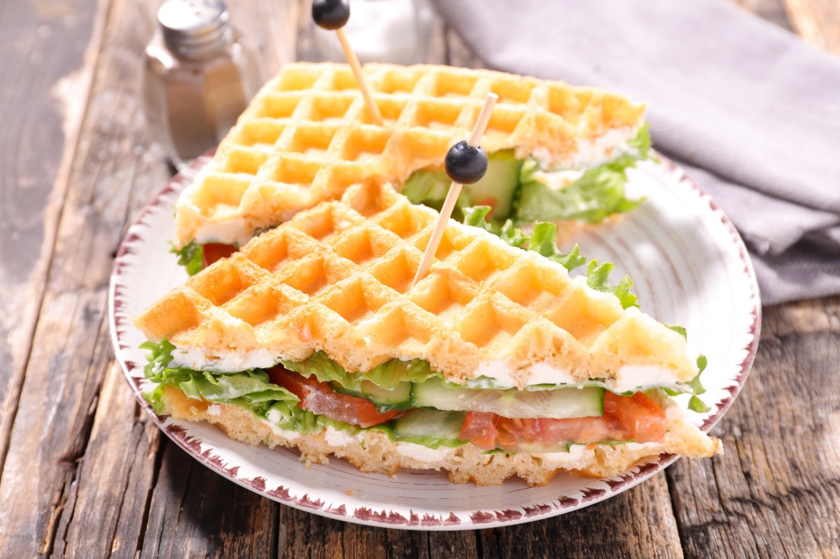 Ein halbiertes Waffel-Sandwich mit Gemüse auf einem Teller.