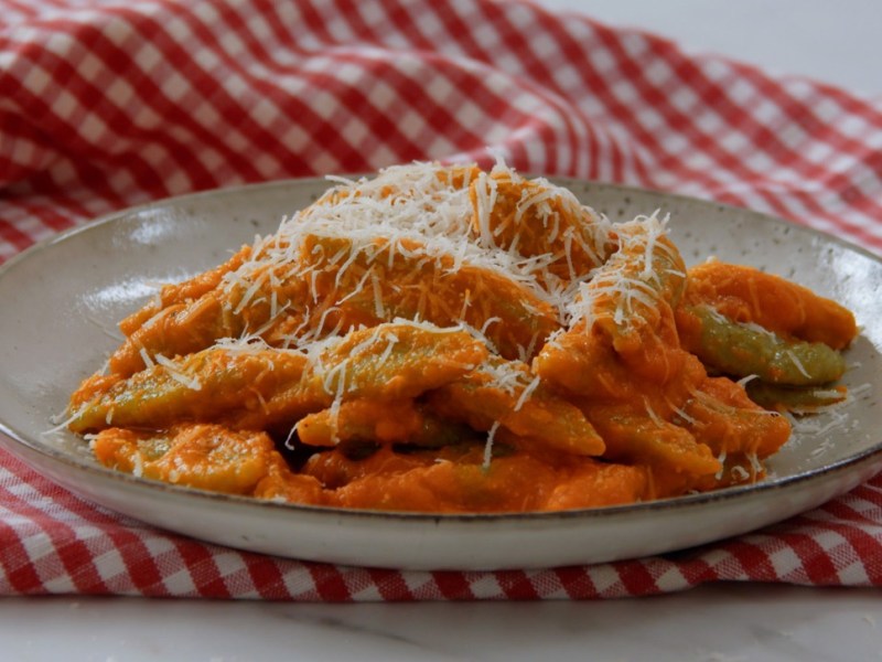 Eine Portion Brokkoli-Schupfnudeln mit geriebenem Parmesan auf einem Teller.